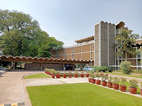 green grass field with trees and concrete building