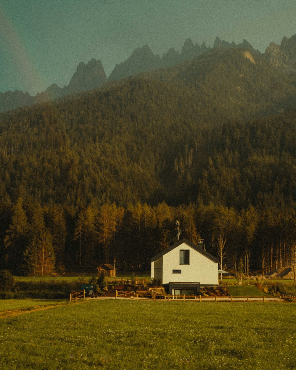 white and brown house near green trees and mountain during daytime