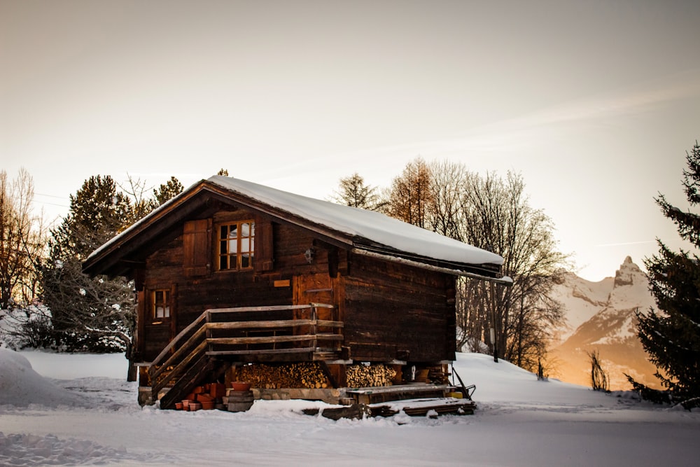 brown wooden house covered with snow during daytime