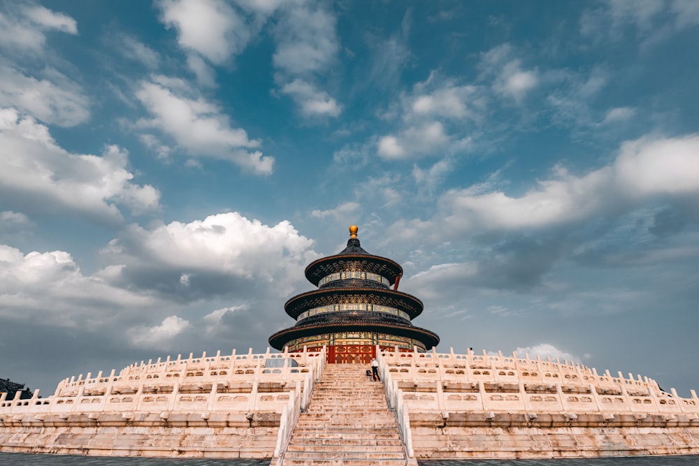 gold and black tower under cloudy sky