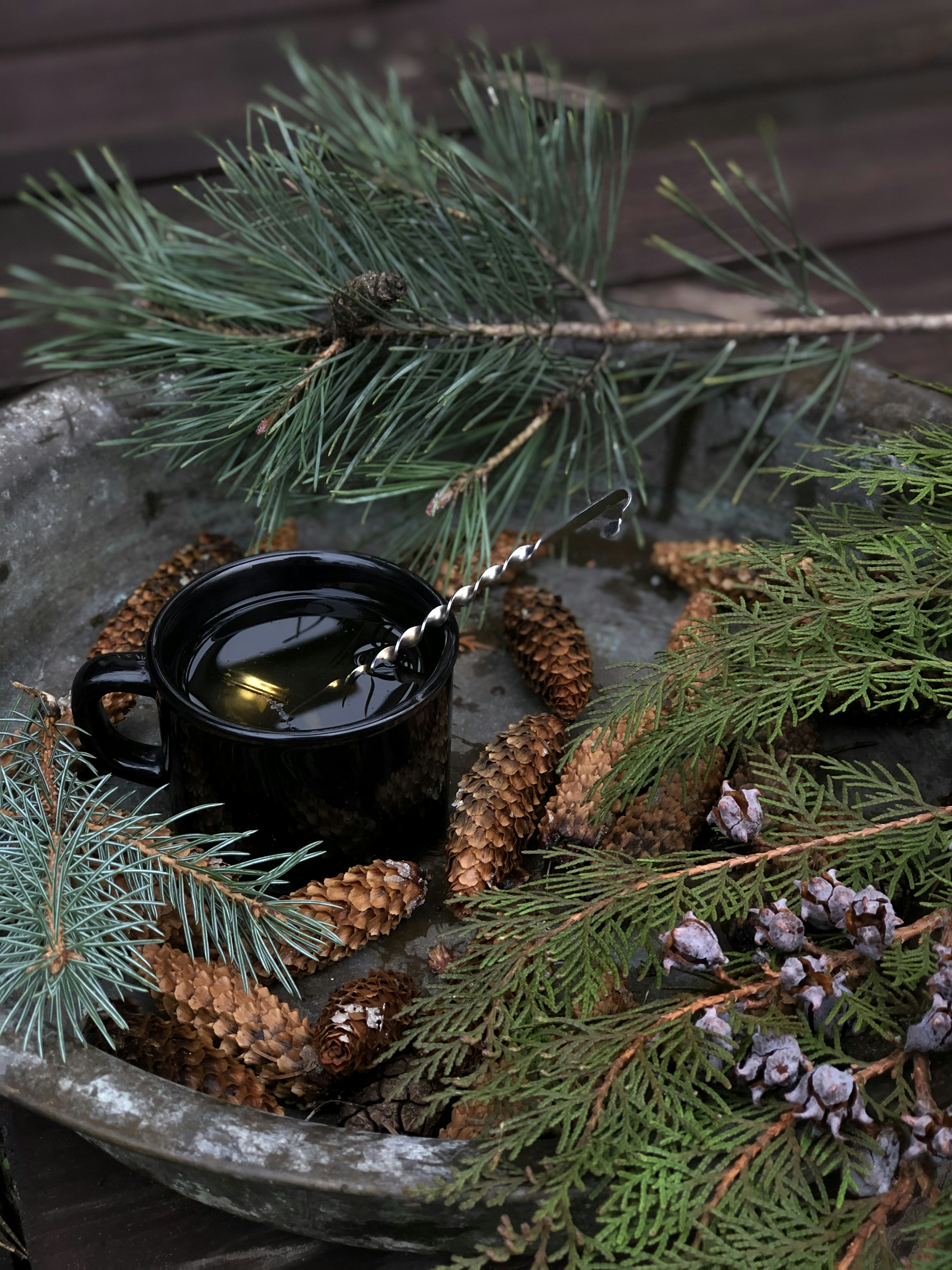 black ceramic mug on brown pine cone