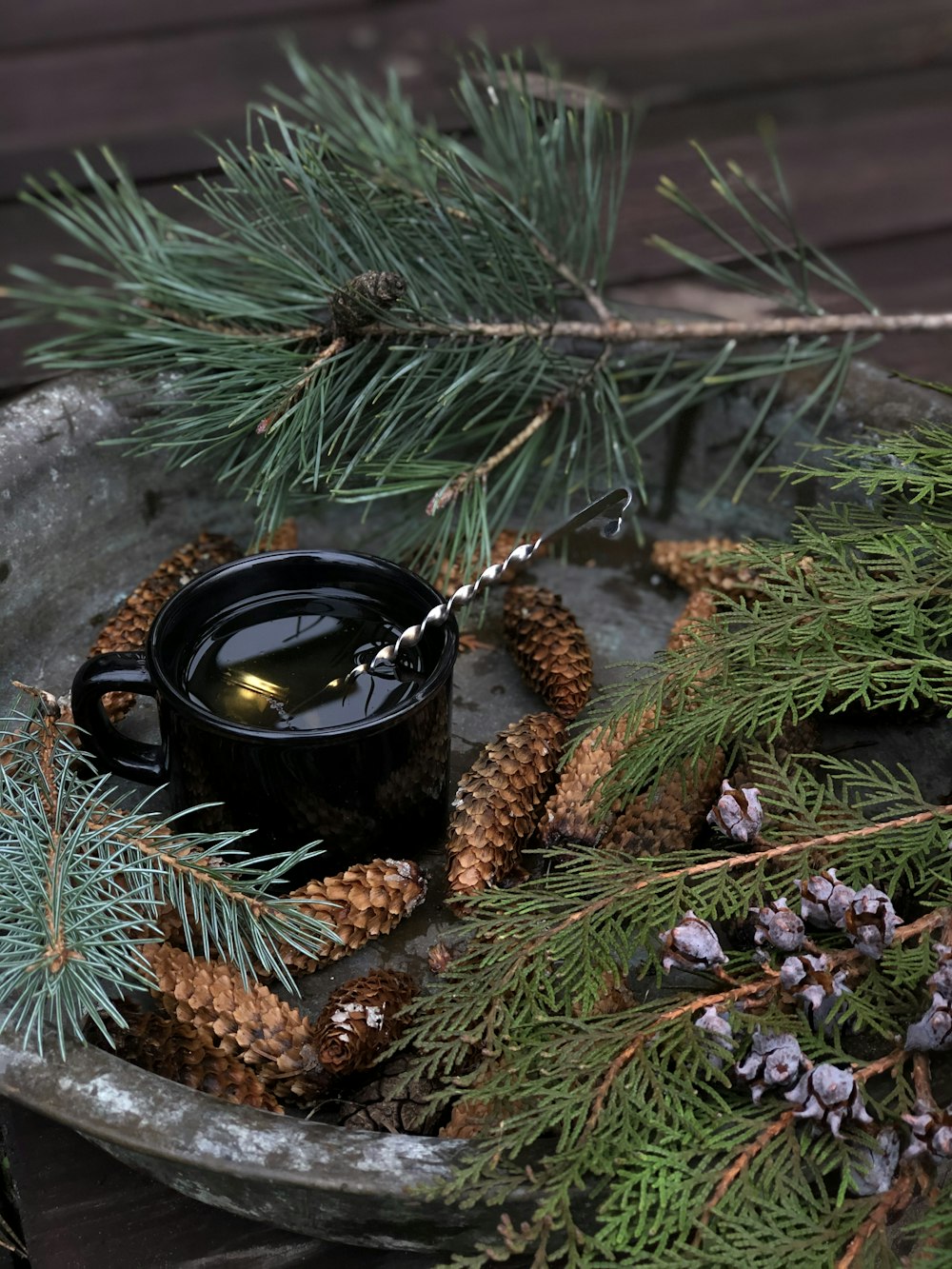 black ceramic mug on brown pine cone