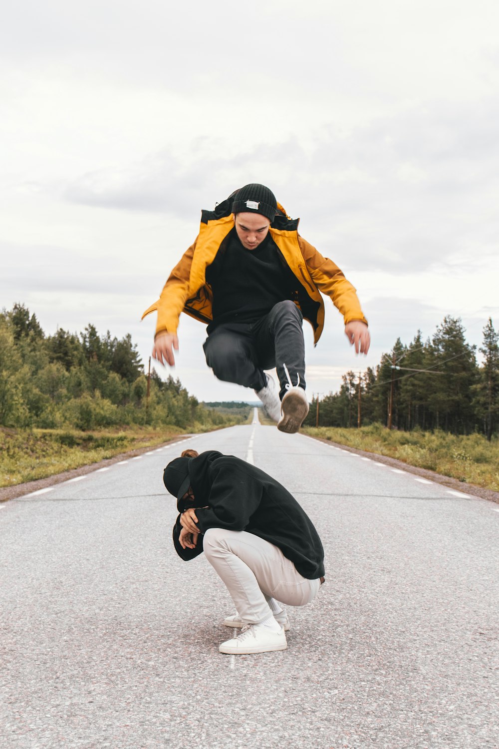 man in orange jacket and white pants doing yoga during daytime