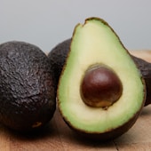 sliced avocado fruit on brown wooden table