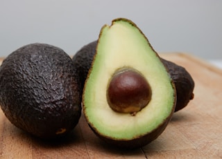 sliced avocado fruit on brown wooden table