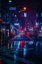 cars on road between high rise buildings during night time