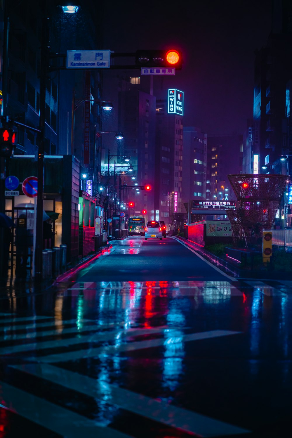 夜間に高層ビルの間を走行する車