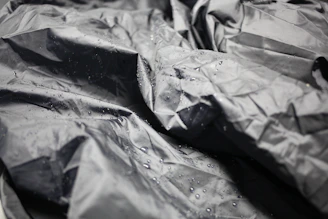 Close-up of a waterproof tablecloth in a subtle gray tone, with water droplets beading on the surface.