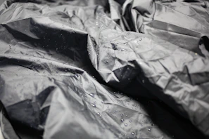 Close-up of a waterproof tablecloth in a subtle gray tone, with water droplets beading on the surface.