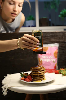 An inviting shot of the pancake mix package surrounded by fresh ingredients like oats, nuts, and berries on a rustic wooden surface.