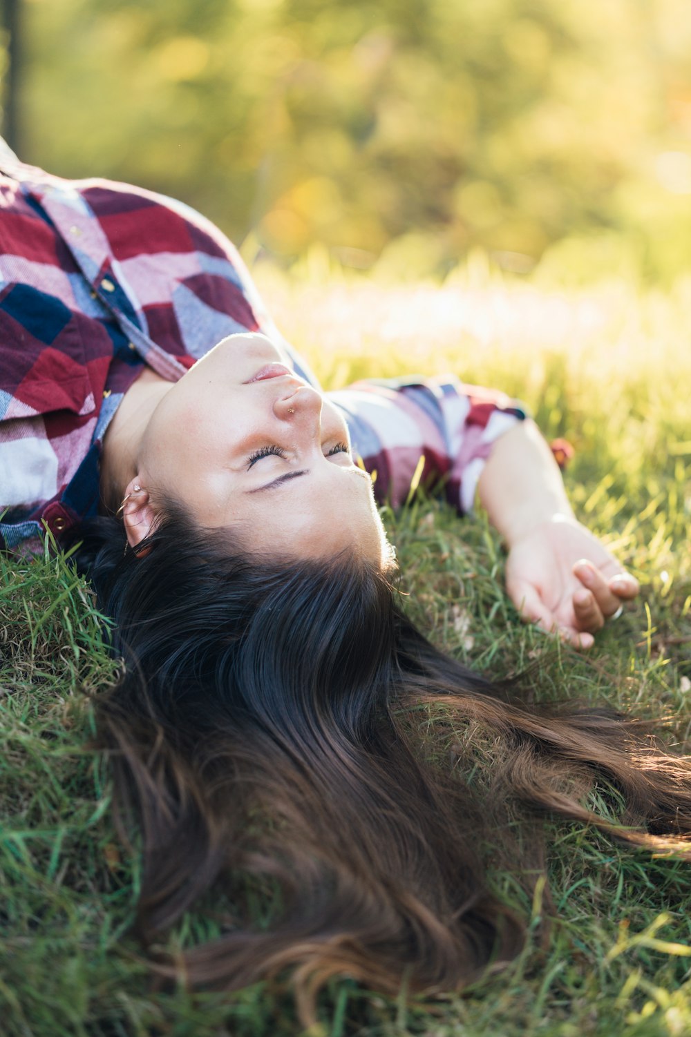 woman in black long sleeve shirt lying on green grass during daytime