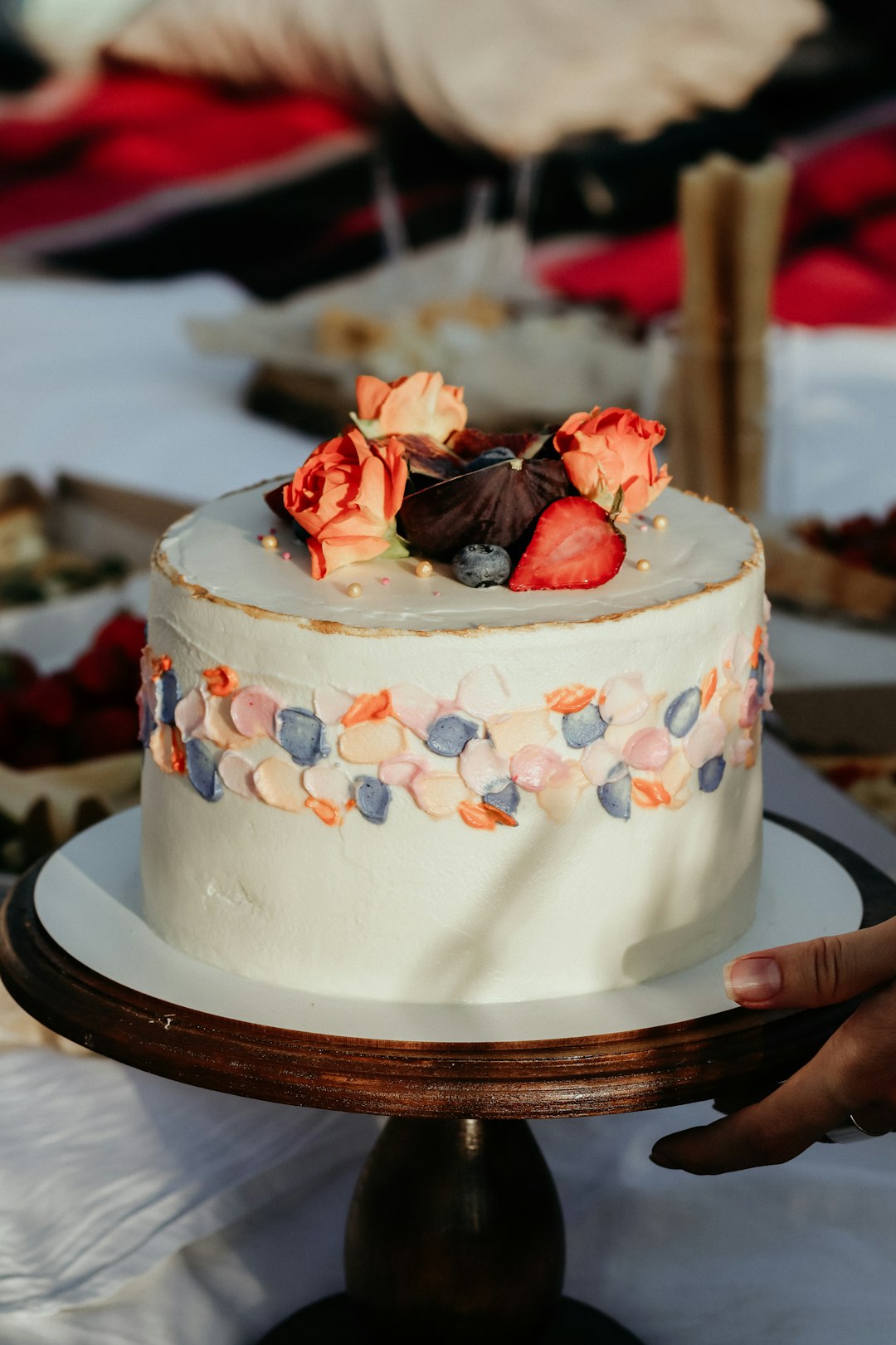 white and red cake with red rose on top