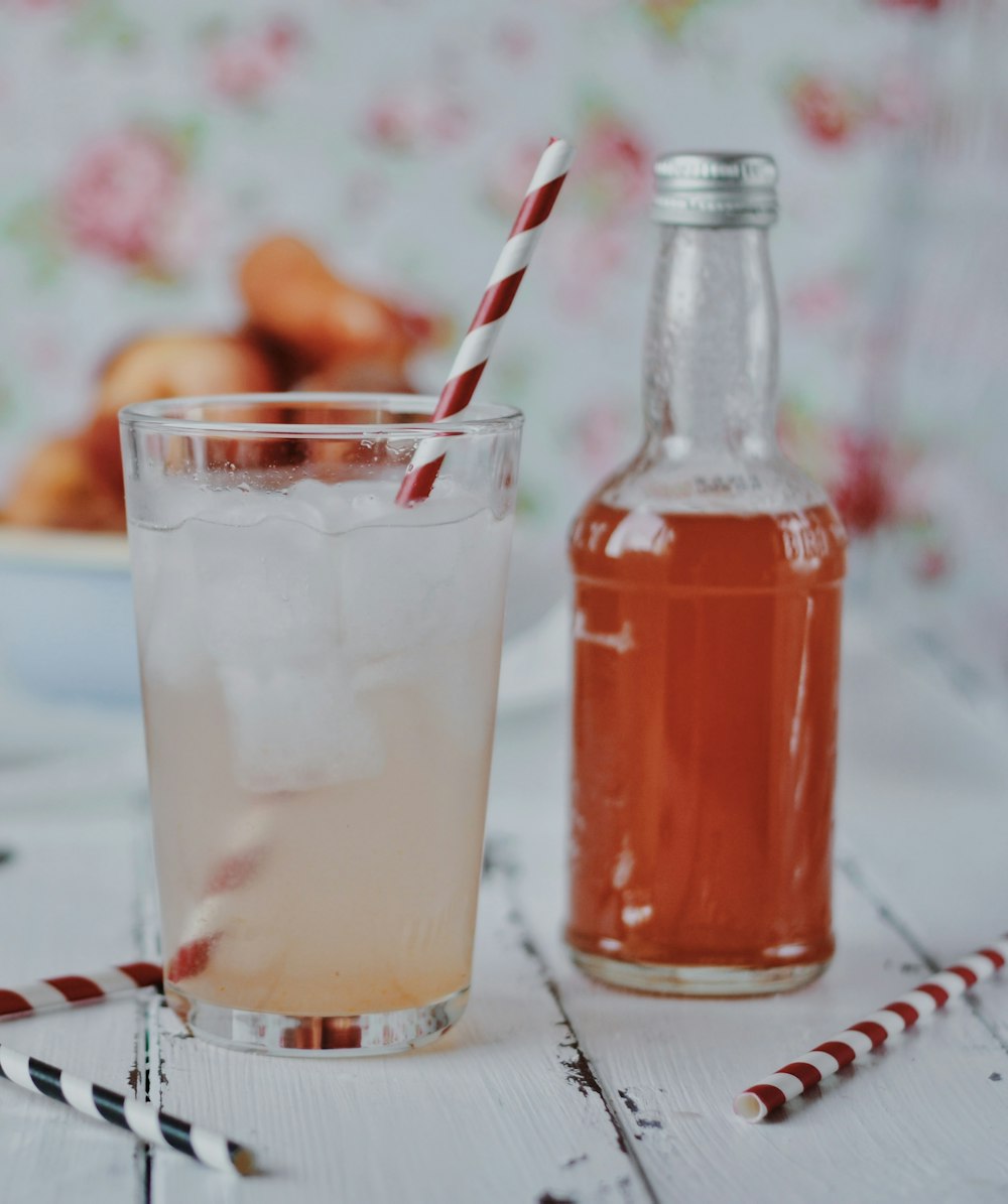 Botella de vidrio transparente con líquido naranja