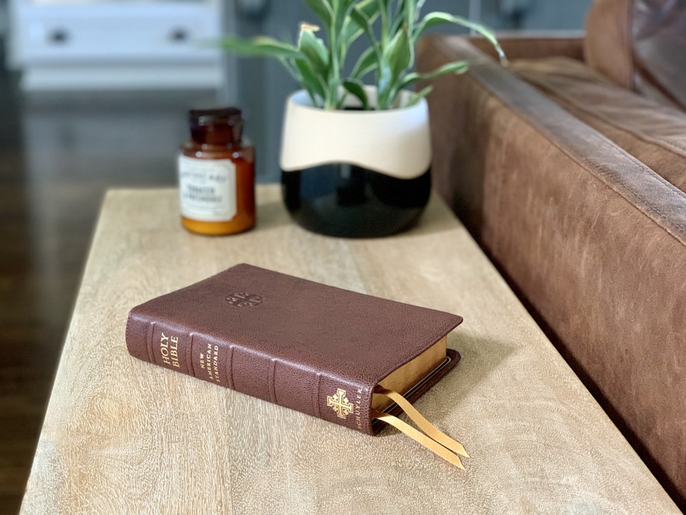 brown hardbound book on brown wooden table