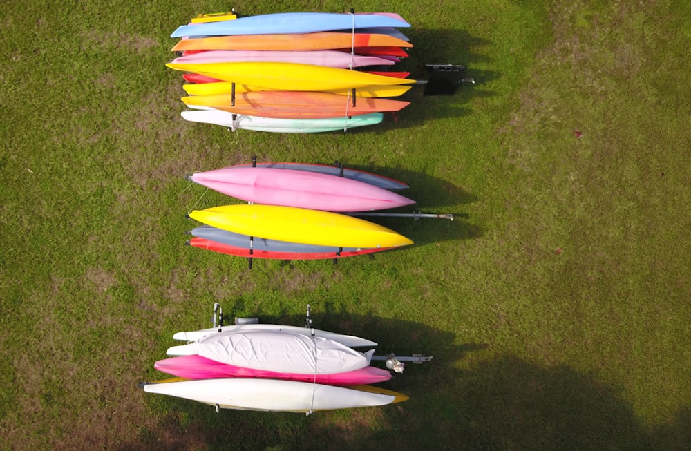 yellow pink and blue kayaks on green grass field