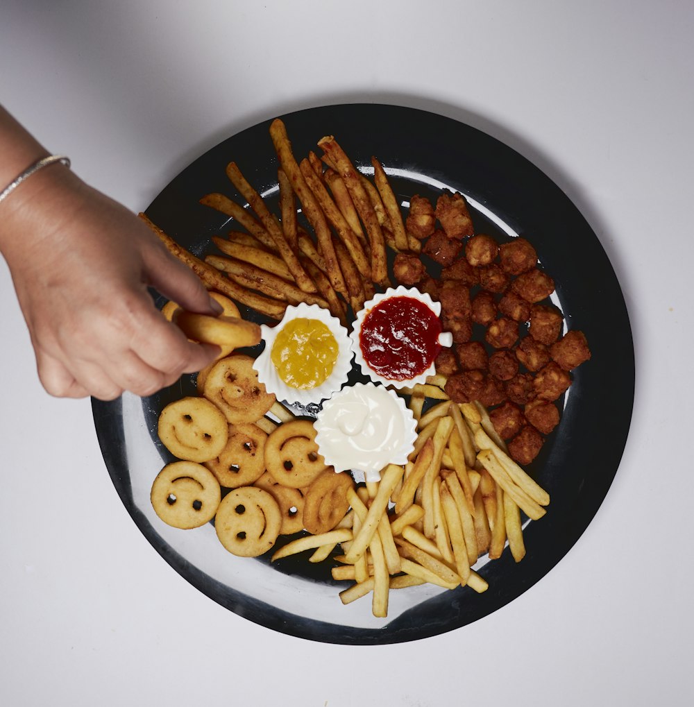 person holding black ceramic bowl with food