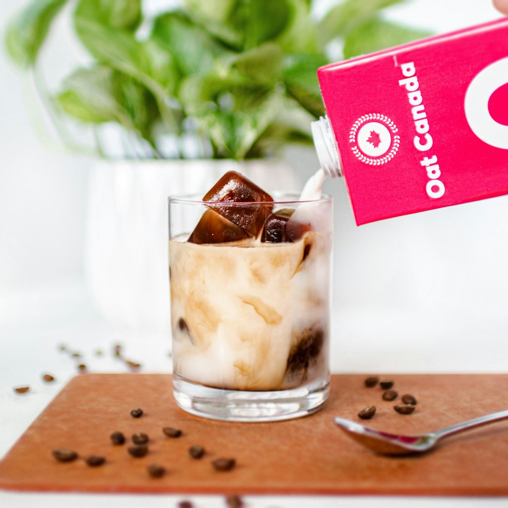 clear drinking glass with ice cream on brown wooden chopping board