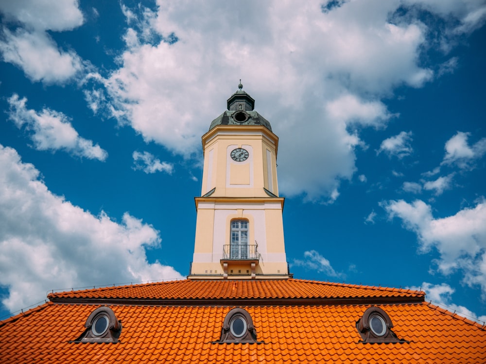 edifício de concreto branco e marrom sob céu azul e nuvens brancas durante o dia