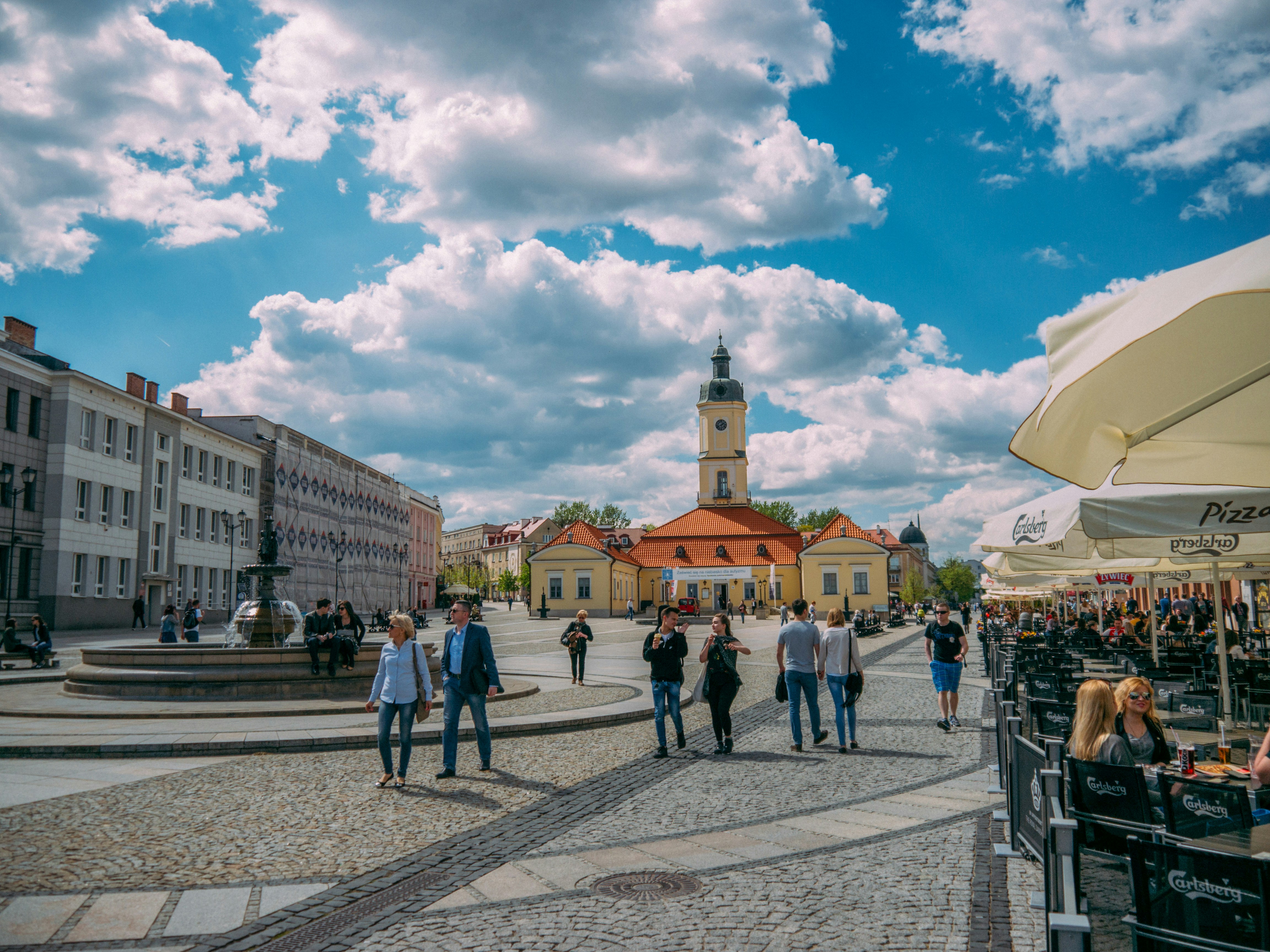 people walking on street near buildings under blue sky during daytime