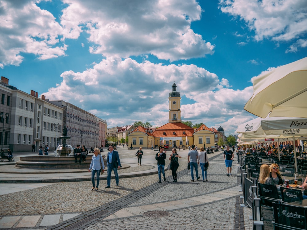 people walking on street near buildings under blue sky during daytime