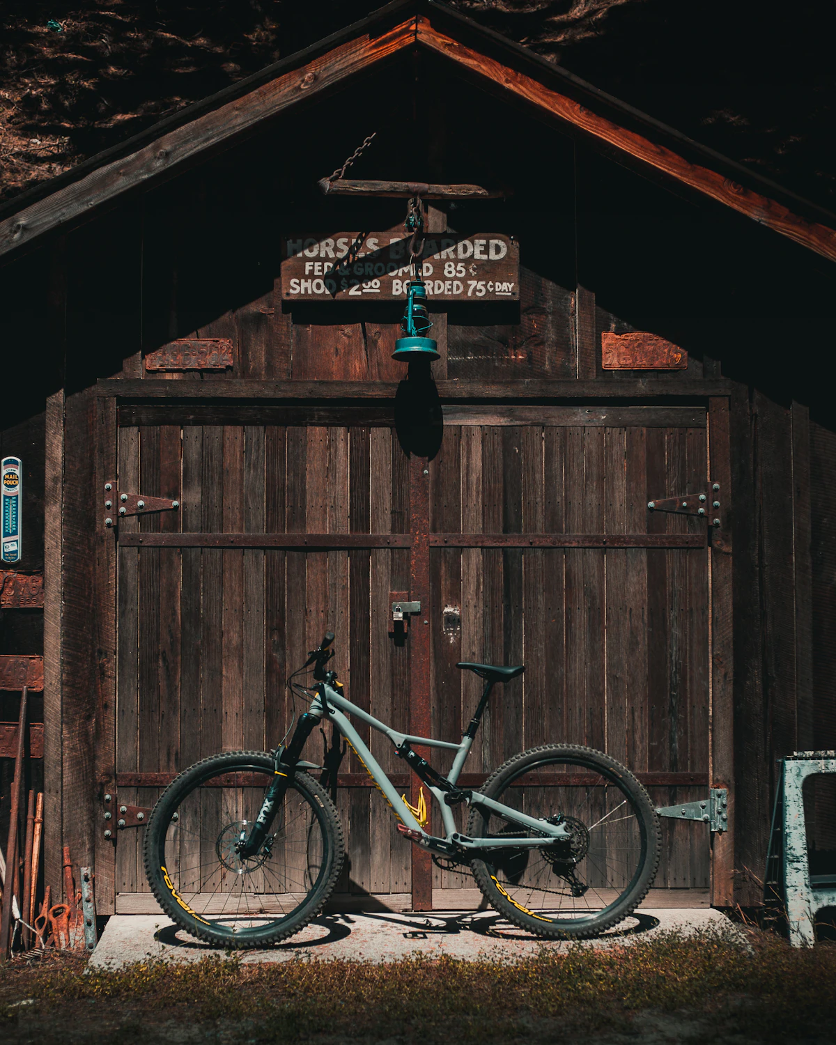A mountain bike parked against an old wooden barn door in Downieville