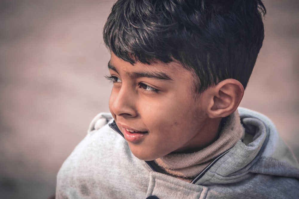 boy in gray hoodie smiling