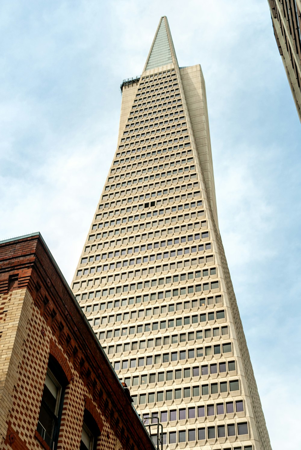 brown concrete building under white clouds during daytime