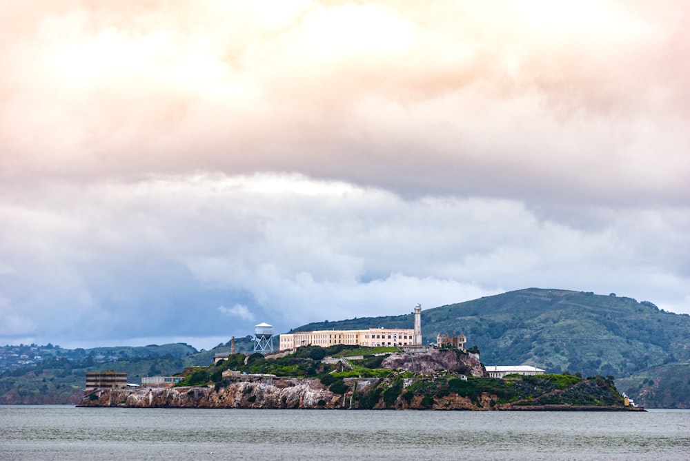 white and brown concrete building near body of water under white clouds during daytime