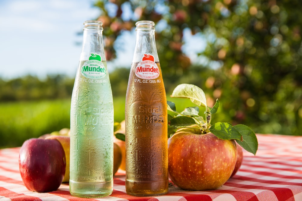 two bottles of apple cider sitting on a table