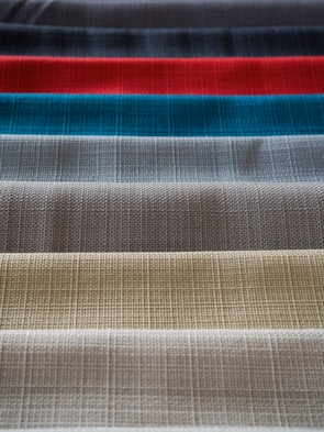Rows of colorful fabric swatches laid out on a wooden table in the workshop.