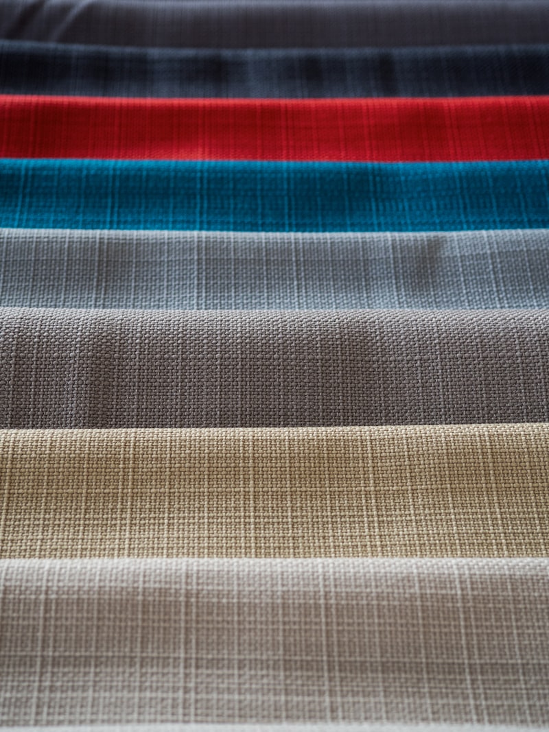 Rolls of colourful fabric textile stacked together showing various patterns and textures