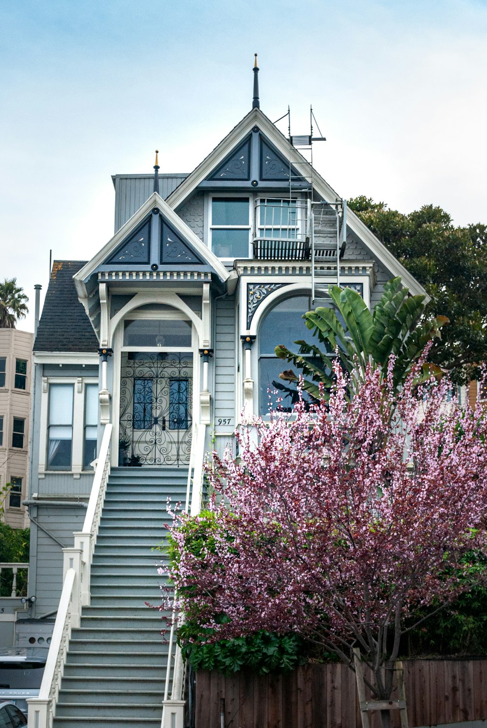 white and gray wooden house near pink flowers