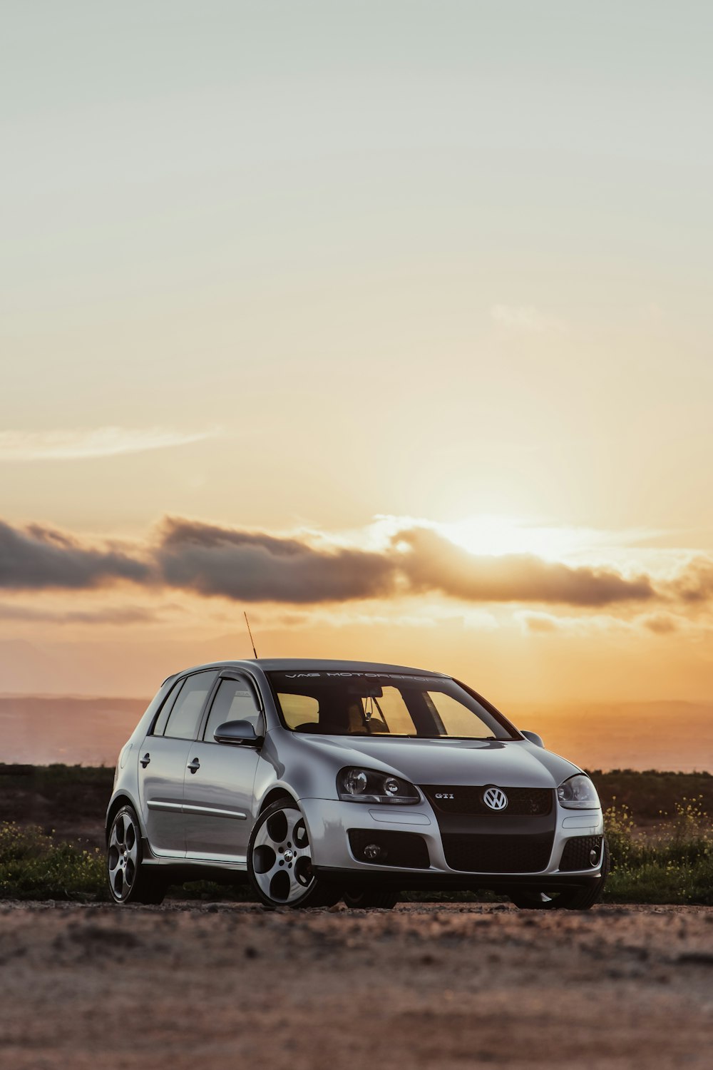 BMW serie X bianca sul campo in erba verde durante il tramonto