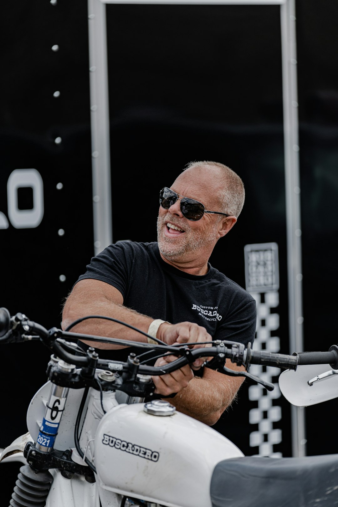 man in black crew neck t-shirt wearing black sunglasses riding on black bicycle during daytime
