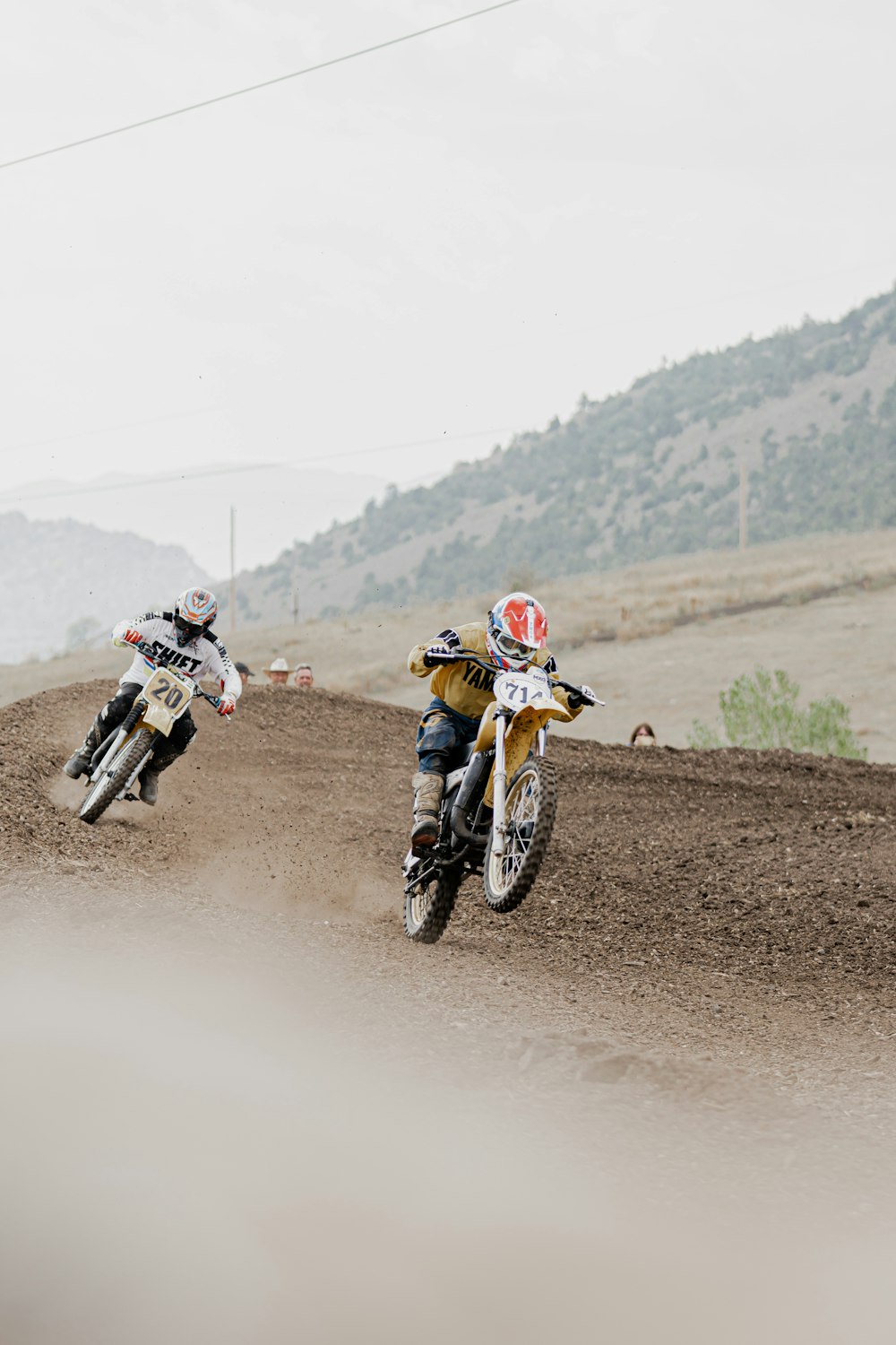 2 hombres montando motos de cross de motocross en caminos de tierra durante el día