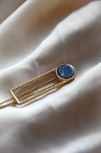 a lapel pin with a blue stone on it