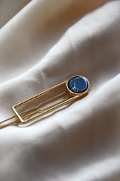 a lapel pin with a blue stone on it