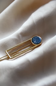 a lapel pin with a blue stone on it