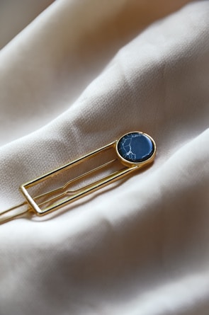 a lapel pin with a blue stone on it
