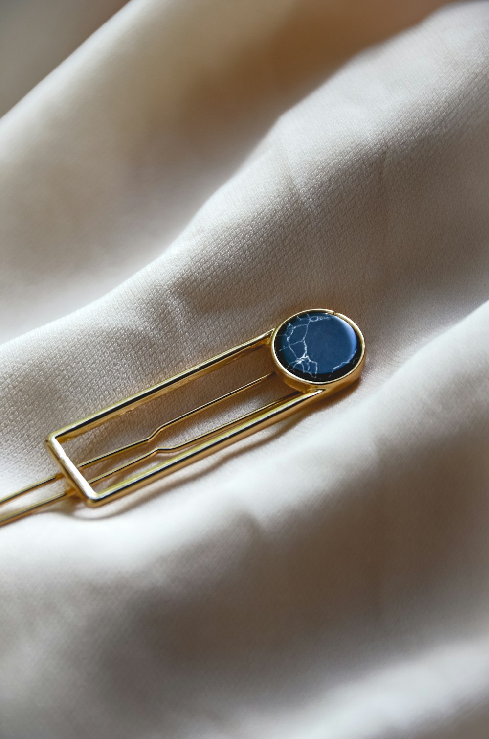 a lapel pin with a blue stone on it