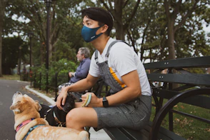 man in white t-shirt and black shorts sitting on black bench during daytime