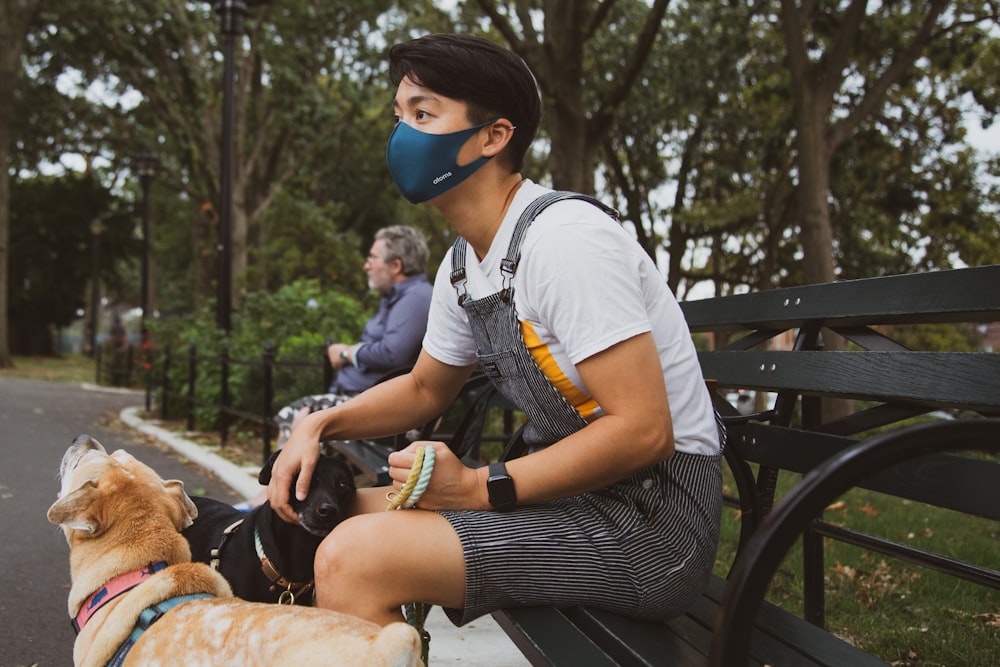 man in white t-shirt and black shorts sitting on black bench during daytime