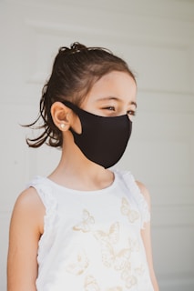 woman in white floral tank top wearing black mask