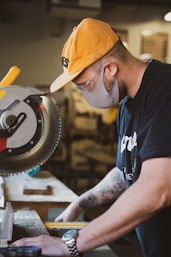 man in blue and white crew neck t-shirt and orange cap holding yellow and black