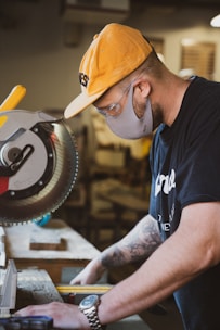 man in blue and white crew neck t-shirt and orange cap holding yellow and black