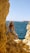 woman in black and white floral spaghetti strap dress standing on brown rock formation near body