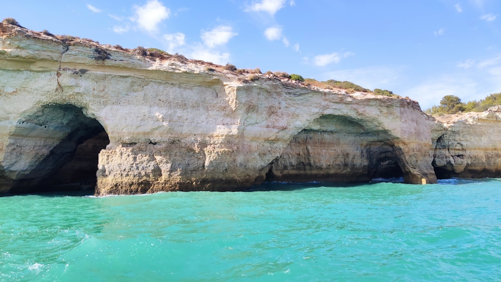 brown rock formation on body of water during daytime