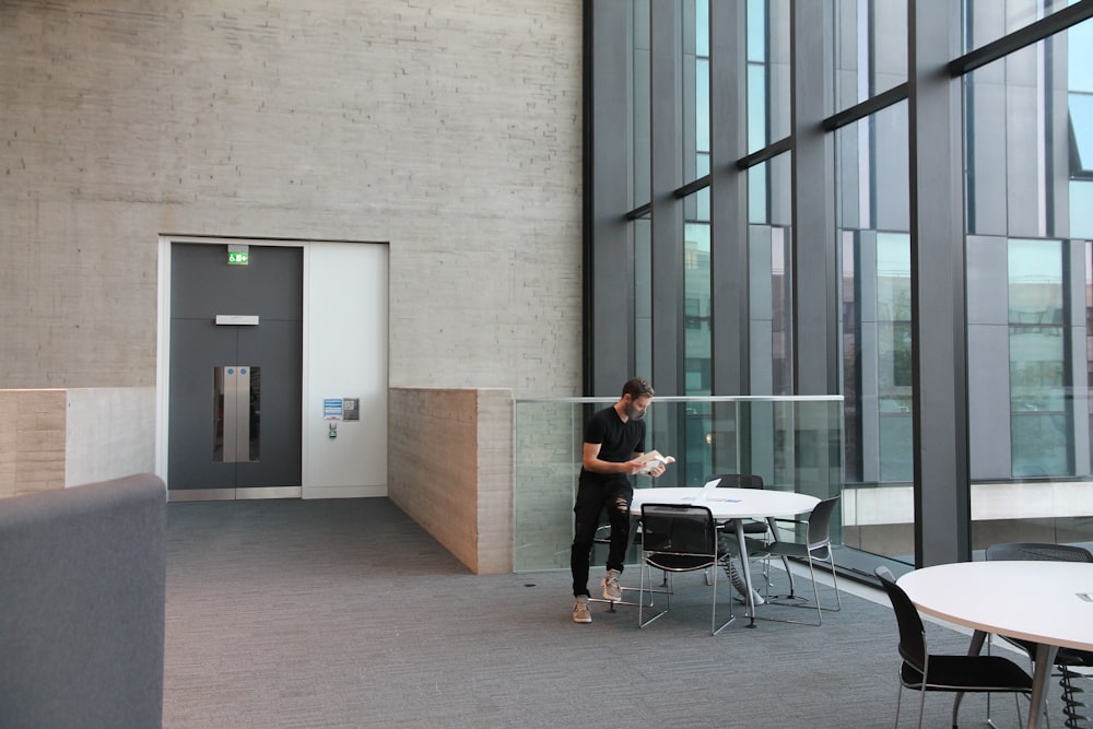 woman in black t-shirt and black pants standing near white table