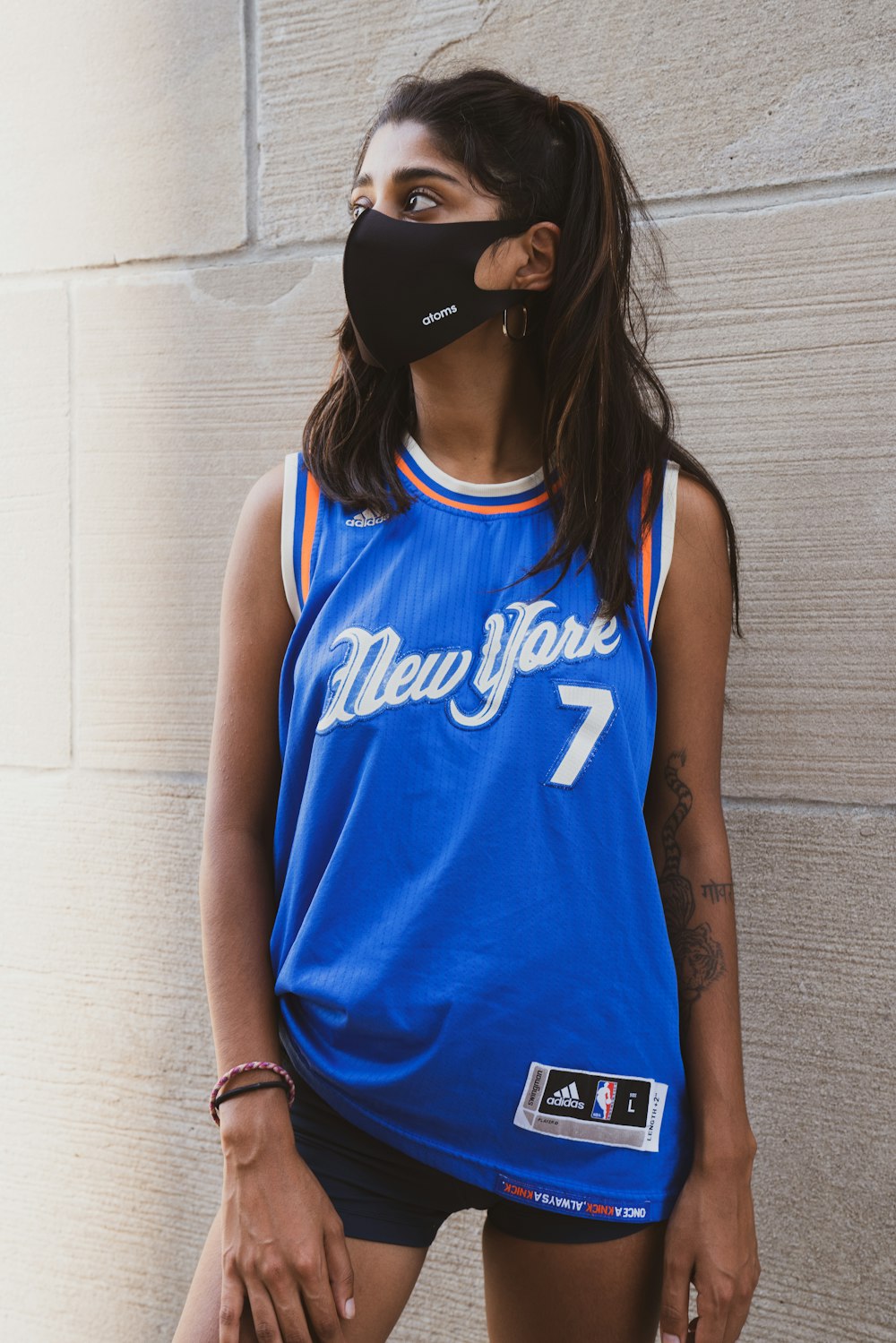 woman in blue and white tank top wearing black cap