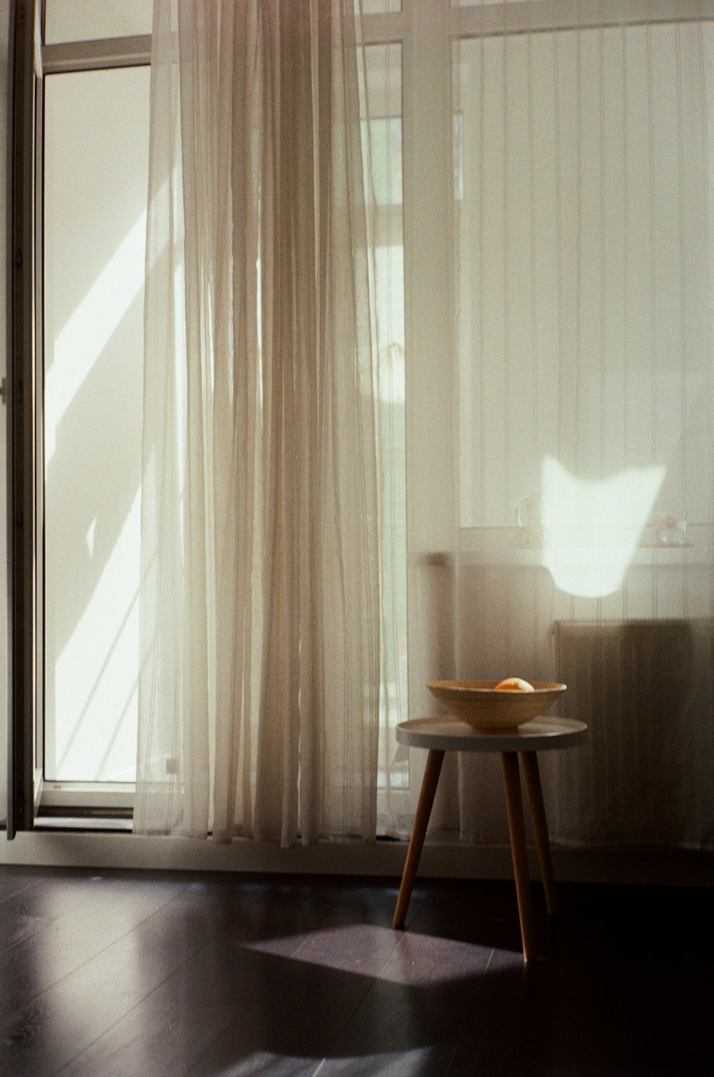 weißer Fenstervorhang in der Nähe von braunem Holztisch